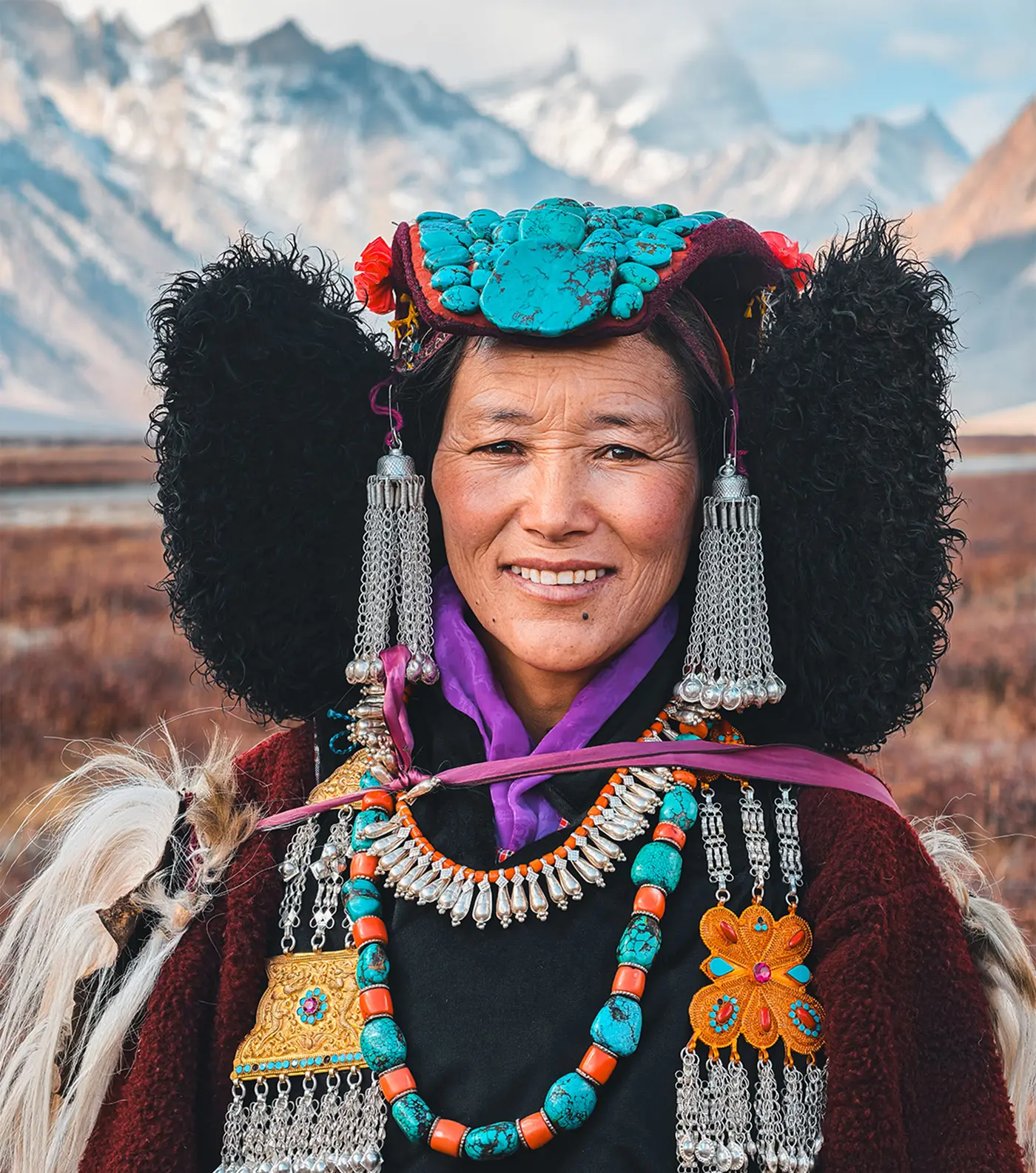 A Ladakhi woman in a turquoise headdress, smiling